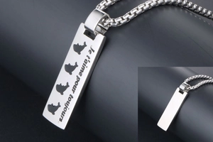 Detailed macro view of rectangle dolphin pendant with Je t'aime pour toujours engraving