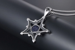 Macro d'un pendentif hexagramme en acier avec pierre de grès bleu et relief de croix