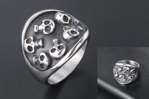 Close-up of gothic skull embossed patterns on silver stainless steel punk ring band