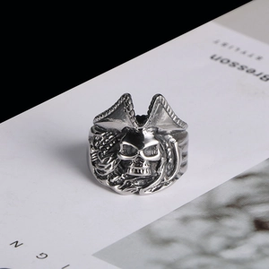 Macro shot of vintage silver devil skull ring with horns and pirate hat on white magazine