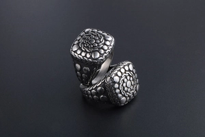 Macro detail of vintage titanium steel rings with embossed pebble patterns and industrial texture