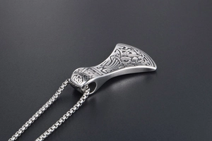 Detail shot of a Viking axe pendant with Celtic knots and a square box chain