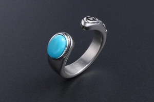 Detail of vintage steel ring featuring turquoise stone and carved wave pattern