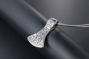 Detailed macro of Viking axe pendant with vintage carvings on stainless steel chain