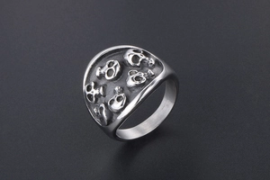 Close-up detail of silver gothic skull ring with embossed punk style textures