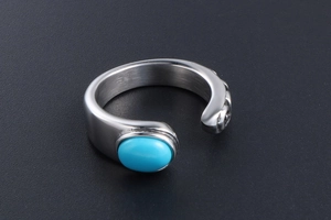 Macro detail of retro stainless steel ring featuring oval turquoise stone and relief pattern