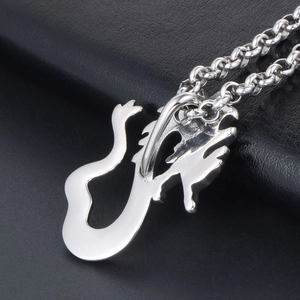 Polished silver dragon pendant necklace with bold link chain on black leather background