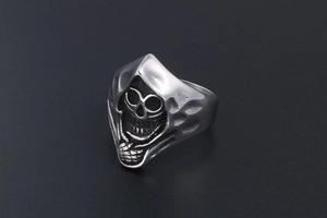 Macro detail of vintage silver skull reaper ring showing gothic engraved texture and finish
