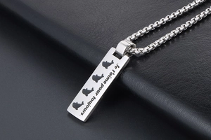 Macro shot of rectangular pendant with dolphin silhouettes and French love engraving