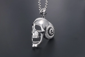Detailed close-up of a punk style stainless steel ram horn skull pendant for men