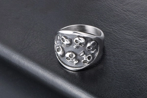 Detailed view of silver skull relief ring with vintage punk finish on black leather