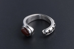 Macro shot of retro steel ring with red gemstone and engraved scroll patterns