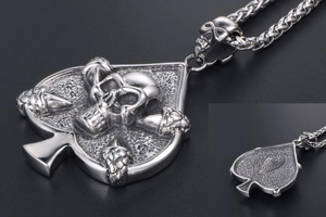 Macro shot of retro spade ace skull pendant with woven wheat chain in silver finish
