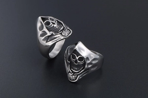 Detailed close-up of two vintage Gothic Grim Reaper rings with antique steel finish