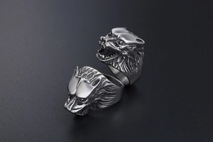 Close-up of retro wolf head rings in vintage steel with detailed punk carvings