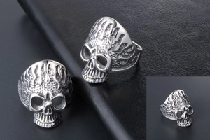 Three views of silver skull ring with flame textures on a black leather background