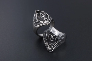 Close-up of vintage grim reaper skull ring with black engraving on titanium steel
