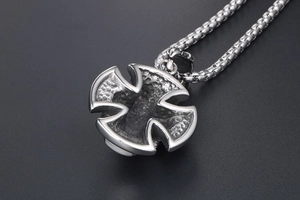 Close-up of retro titanium steel cross pendant with hammered texture and vintage finish