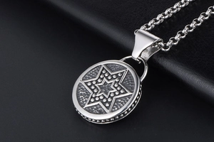 Gros plan d'un pendentif rond vintage avec étoile hexagonale et texture martelée fine