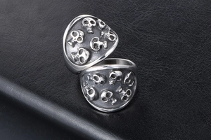 Detailed view of silver skull punk ring with vintage engraving on black leather