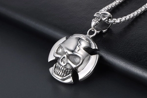 Macro shot of vintage skull pendant featuring detailed silver cracks and box chain texture