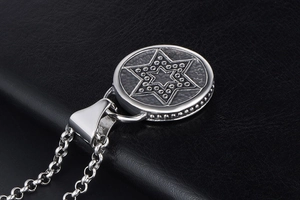 Détail macro du collier rond en argent avec hexagramme gravé et bord perlé