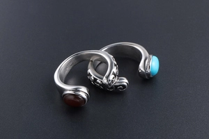 Detailed shot of retro stainless steel rings with red agate and turquoise gemstones