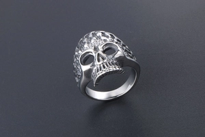 Macro shot of silver steel skull ring with intricate scale texture and gothic details