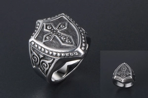 Macro view of vintage titanium steel men's ring with embossed cross and shield motifs