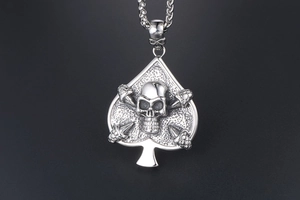 Macro shot of silver spade skull pendant with crossbone detail on punk chain