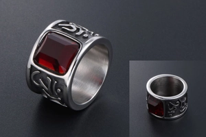 Macro detail of vintage wide band ring with square red gemstone and embossed symbols