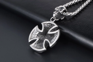 Macro shot of punk style stainless steel cross pendant with skull detail and box chain