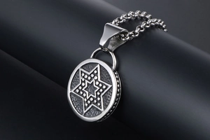 Gros plan du pendentif étoile hexagonale en argent avec texture vintage et chaîne à maillons