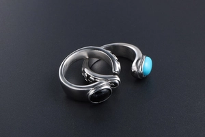 Detail of vintage titanium rings with embossed texture and colorful gemstones