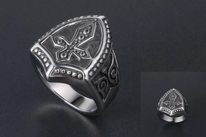 Macro view of retro shield-shaped titanium steel ring with gothic cross relief detail