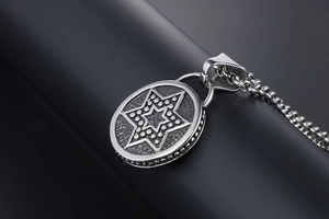 Gros plan d'un pendentif étoile hexagonale vintage en argent avec chaîne à billes