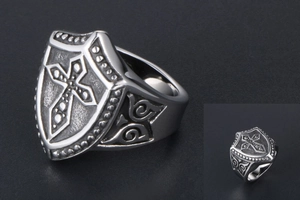 Close-up of vintage titanium steel shield ring with embossed gothic cross detail