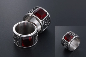 Detailed relief patterns on a vintage stainless steel ring with a red gemstone inlay
