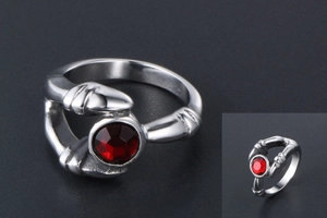 Macro detail of gothic claw ring in silver steel featuring a faceted red gemstone inlay