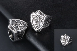 Close-up of retro shield cross ring in silver titanium steel on black leather base