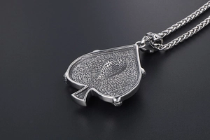Close-up of vintage spade pendant with honeycomb texture and skull link detail