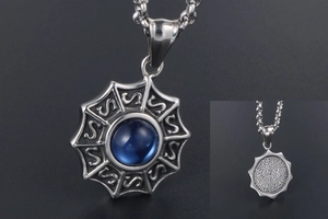 Détail d'un pendentif vintage en acier titane avec zircon bleu et motifs sculptés S