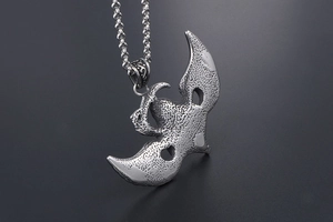 Detailed close-up of punk style grim reaper wings pendant with textured hammered finish