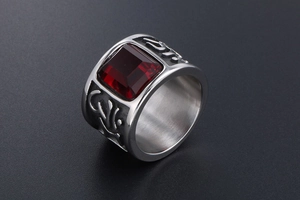 Macro shot of wide band ring featuring red square gemstone and vintage relief carving