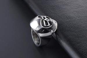 Detailed view of silver skull relief ring with gothic rock design on black leather