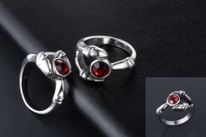 Macro detail of gothic vintage silver ring with a vibrant round red gemstone inlay