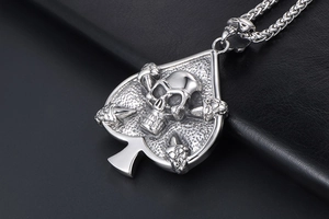 Detailed view of silver skull and spade pendant on thick woven chain over black leather