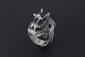 Macro detail of vintage silver dragon ring with intricate scales and punk dragon head design