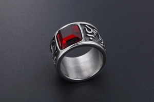 Macro detail of vintage wide steel ring with rectangular red gemstone and engraved patterns