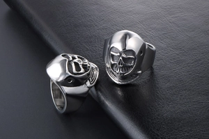 Macro shot of detailed punk skull mask rings in silver titanium steel for men